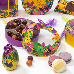 Shirley "Exotique" Photo numéro 2 : Boîte ronde Shirley "Exotique" avec fenêtre transparente, parfaite pour présenter chocolats et gourmandises de Pâques avec style et audace.